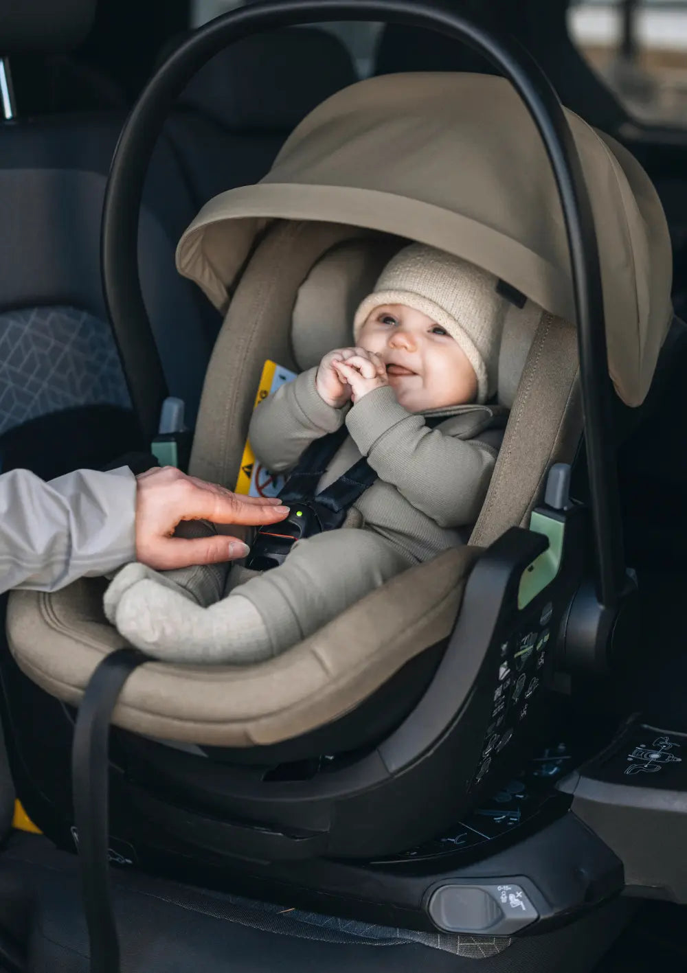 Baby kiegt sicher angeschnallt in der Thule Babyschale 'Maple Connect' Faded Khaki