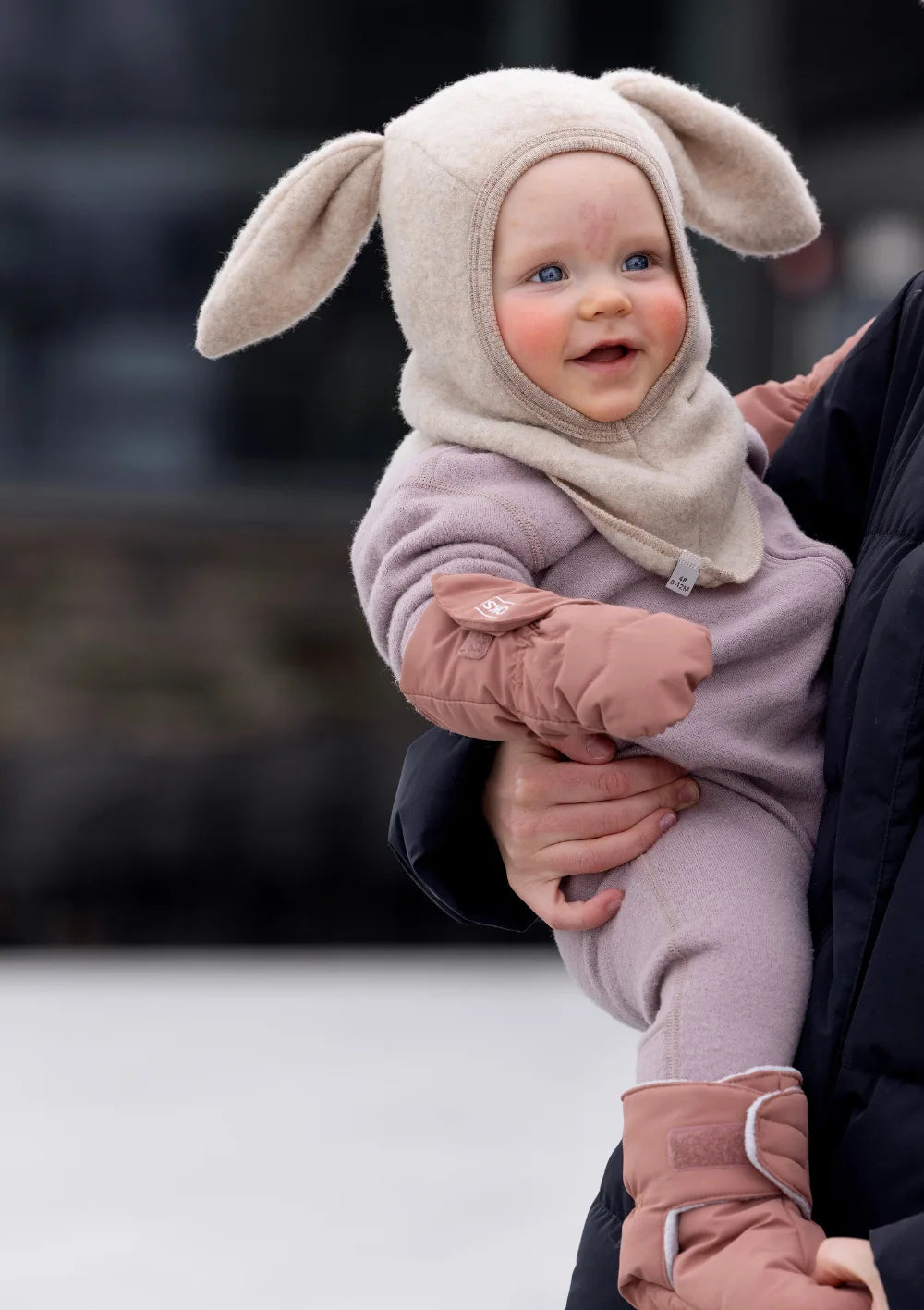 Baby mit Hasenmütze trägt die rosafarbenen Voksi Baby Fäustlinge  und Booties Blush Pink