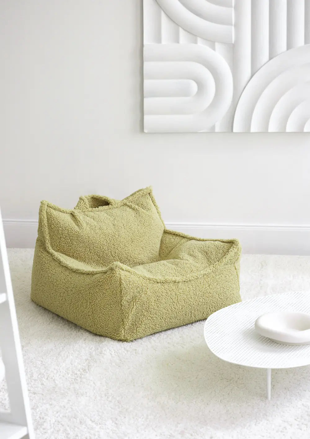 Der hellgrüne Wigiwama Sitzsack Teddy Matcha aus weichem Plüsch steht freistehend in einem modern eingerichteten, hellen Raum.