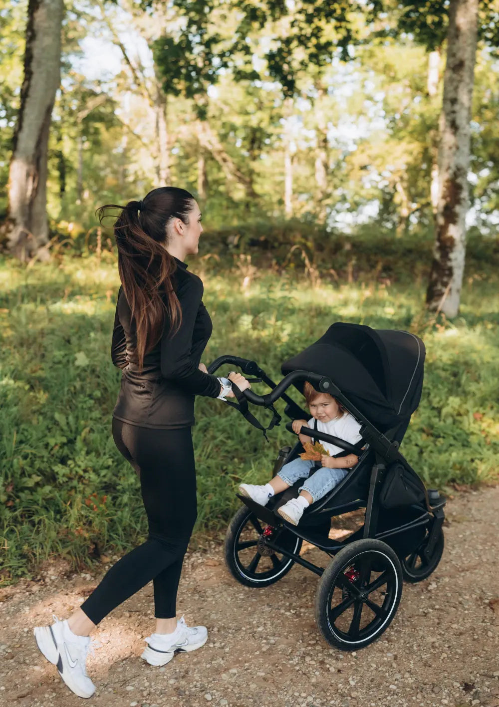 Frau beim Joggen im WAld mit dem tfk Kinderwagen-Set 'pro' Schwarz