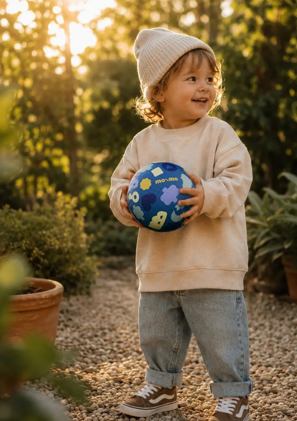 Junge spielt draußen mit dem Ball aus dem  mo:mo Starter-Set 'Bouncing Buddy' Spielball mit App-Zugang Aqua